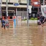 Tourist wade through flood waters in Chiang Mai city - IMage Thai PBS