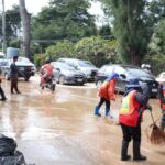 District workers in Chiang Mai clean mud from the streets