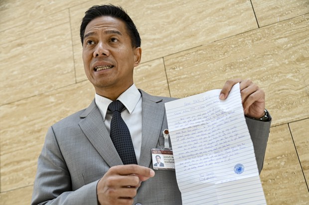 Thai opposition lawmaker Kannavee Suebsang displays a letter he said was written by detained Uyghurs to the Thai government asking to be allowed to go to a third country, at parliament in Bangkok on March 4, 2025.